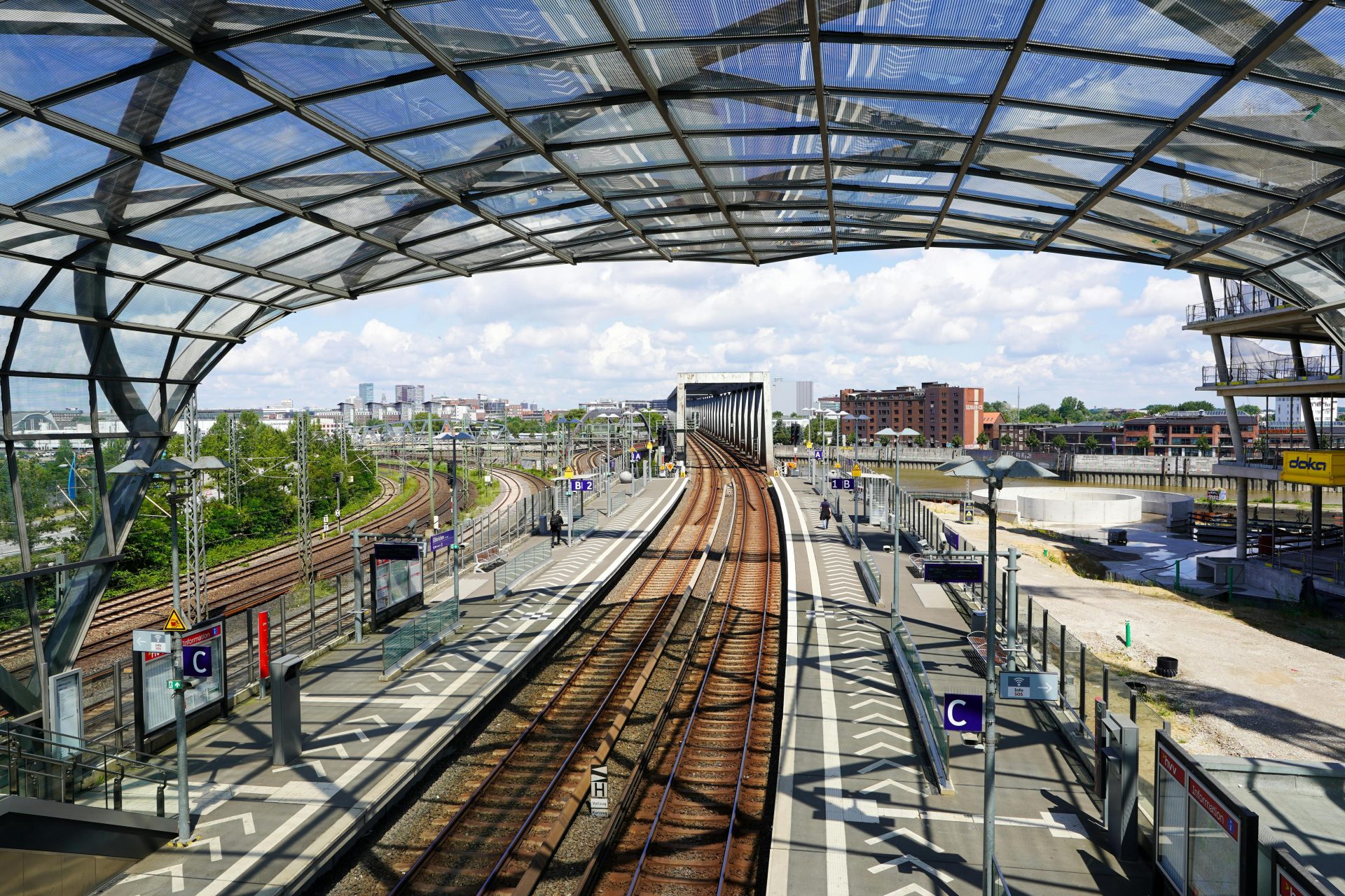 Futuristischer Bahnhof in Hamburg, Deutschland, mit eleganter Architektur und Gleisen unter einem Glasdach.